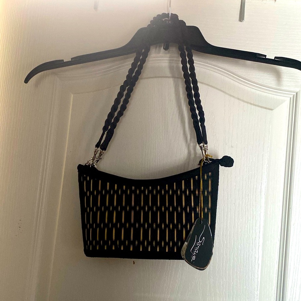 Black and white wicker mini bag made in Cambodia handmade. Two pockets inside.